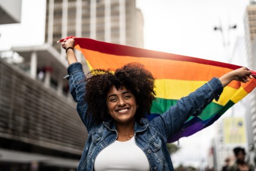 Woman waving rainbow flag at pride parade