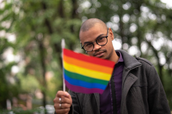 black man holding rainbow flag