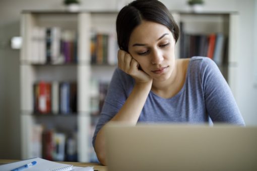 Woman depressed in front of laptop computer